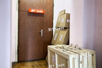 Упаковані картини в дерев'яних ящиках та картонних коробках біля дверей з вивіскою 