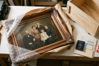 Antique family portrait with packing materials, wooden crate and documents for international transport