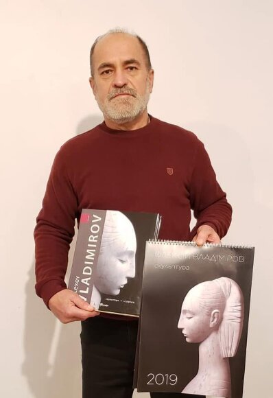 Скульптор Владимиров Алексей держит в руках каталог его работ и календарь с его скульптурами